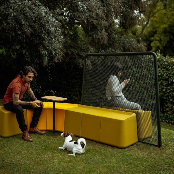 Modern outdoor seating in vibrant yellow with minimalist black accents, surrounded by lush greenery. Perfect for relaxation.