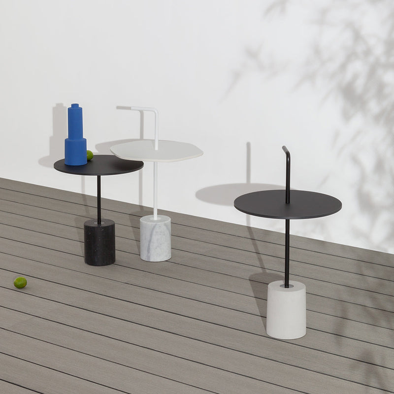 Three modern side tables in black, white, and gray, featuring sleek round tops and cylindrical bases.