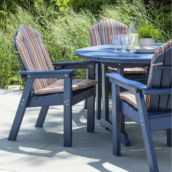 "Blue outdoor dining set with striped cushions in shades of red, orange, and yellow against a green backdrop."