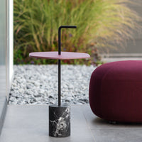 Pink tabletop with black accents and a textured black marble base. Modern design for stylish spaces.