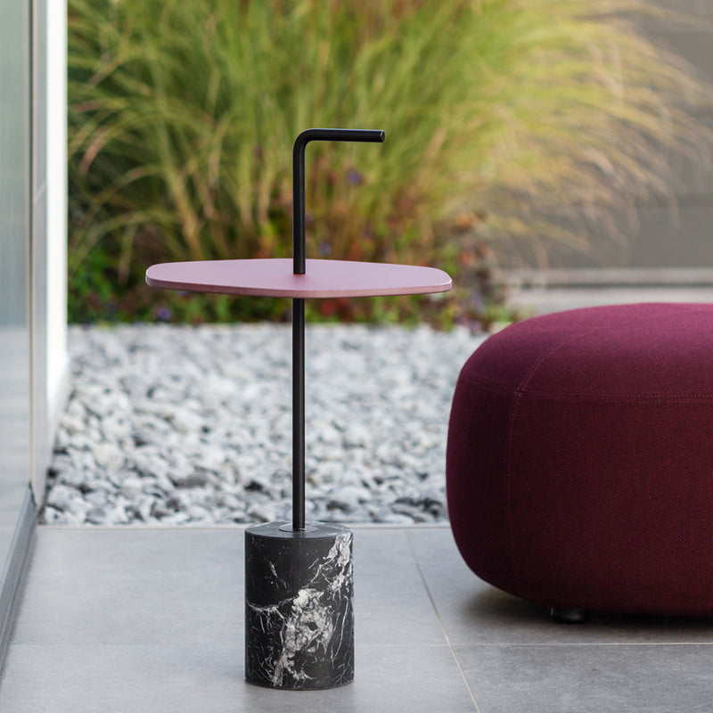 Pink tabletop with black accents and a textured black marble base. Modern design for stylish spaces.