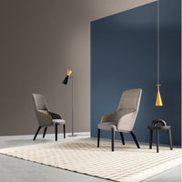 Modern chairs in soft gray, set against a deep blue and earthy brown backdrop, with a geometric beige rug.