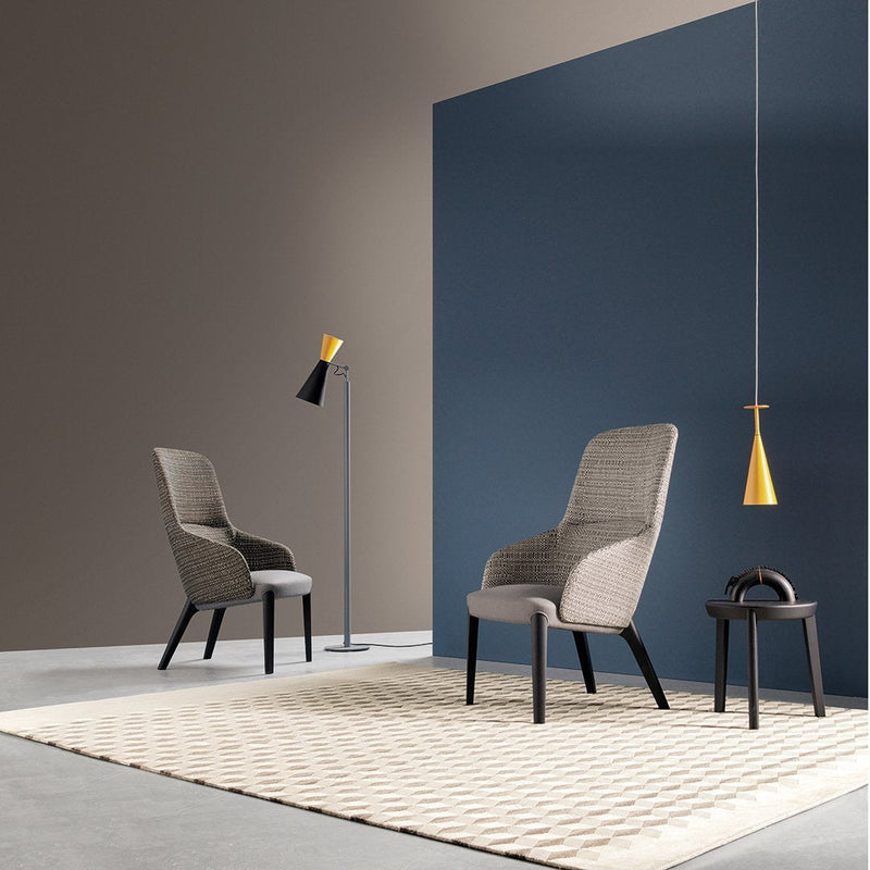 Modern chairs in soft gray, set against a deep blue and earthy brown backdrop, with a geometric beige rug.