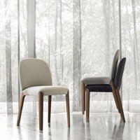 Two stylish chairs in beige and dark gray fabrics, highlighting modern design with wooden legs against a soft backdrop.
