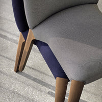 Contemporary chair featuring grey and navy upholstery with sleek wooden legs and a minimalist design.