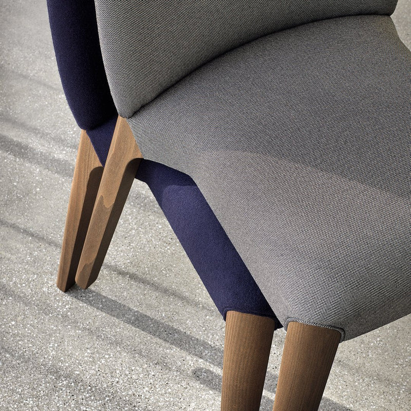 Contemporary chair featuring grey and navy upholstery with sleek wooden legs and a minimalist design.