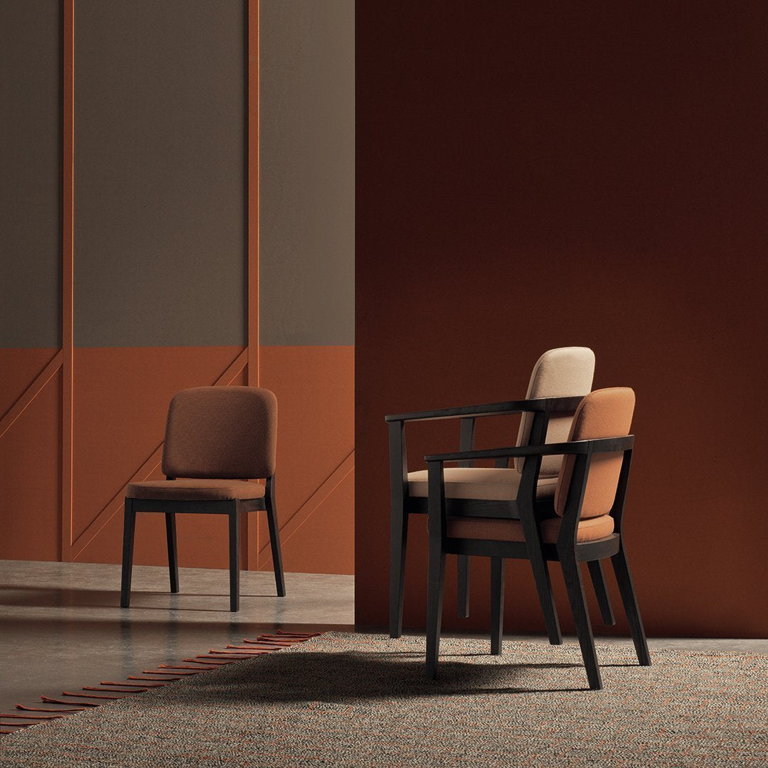 Stylish chairs featuring a mix of earthy browns and muted tones against a warm, textured backdrop.