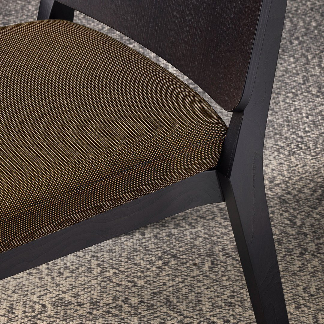 Brown fabric upholstery paired with a sleek black wood frame, showcasing a subtle texture and minimalist design.