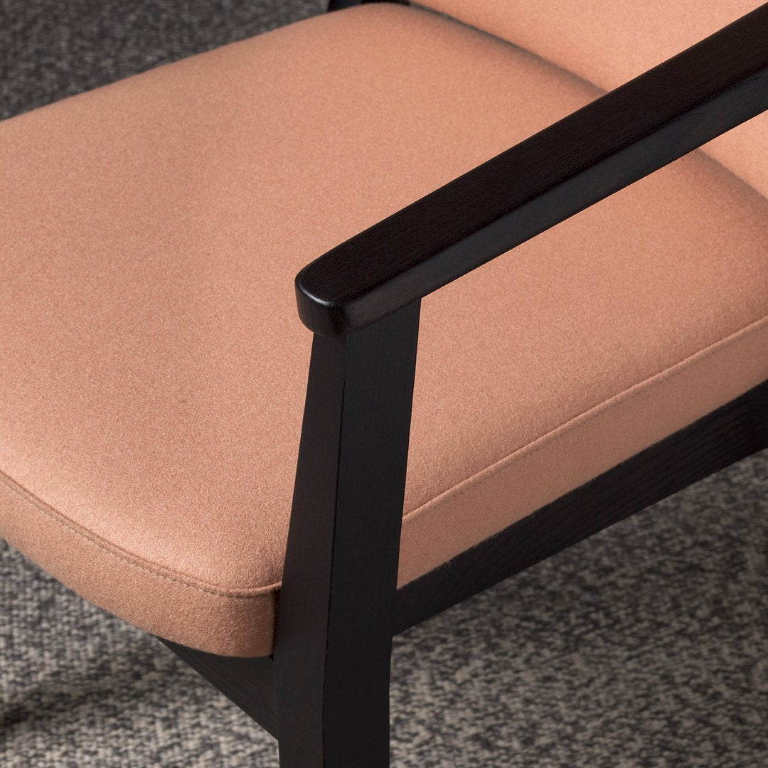 Blush pink upholstery with a sleek black frame, showcasing a modern, minimalist design.