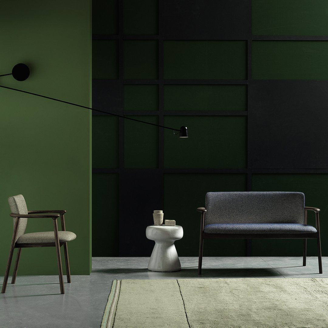Modern living space featuring a green and black color scheme with textured patterns on the rug and sofa upholstery.