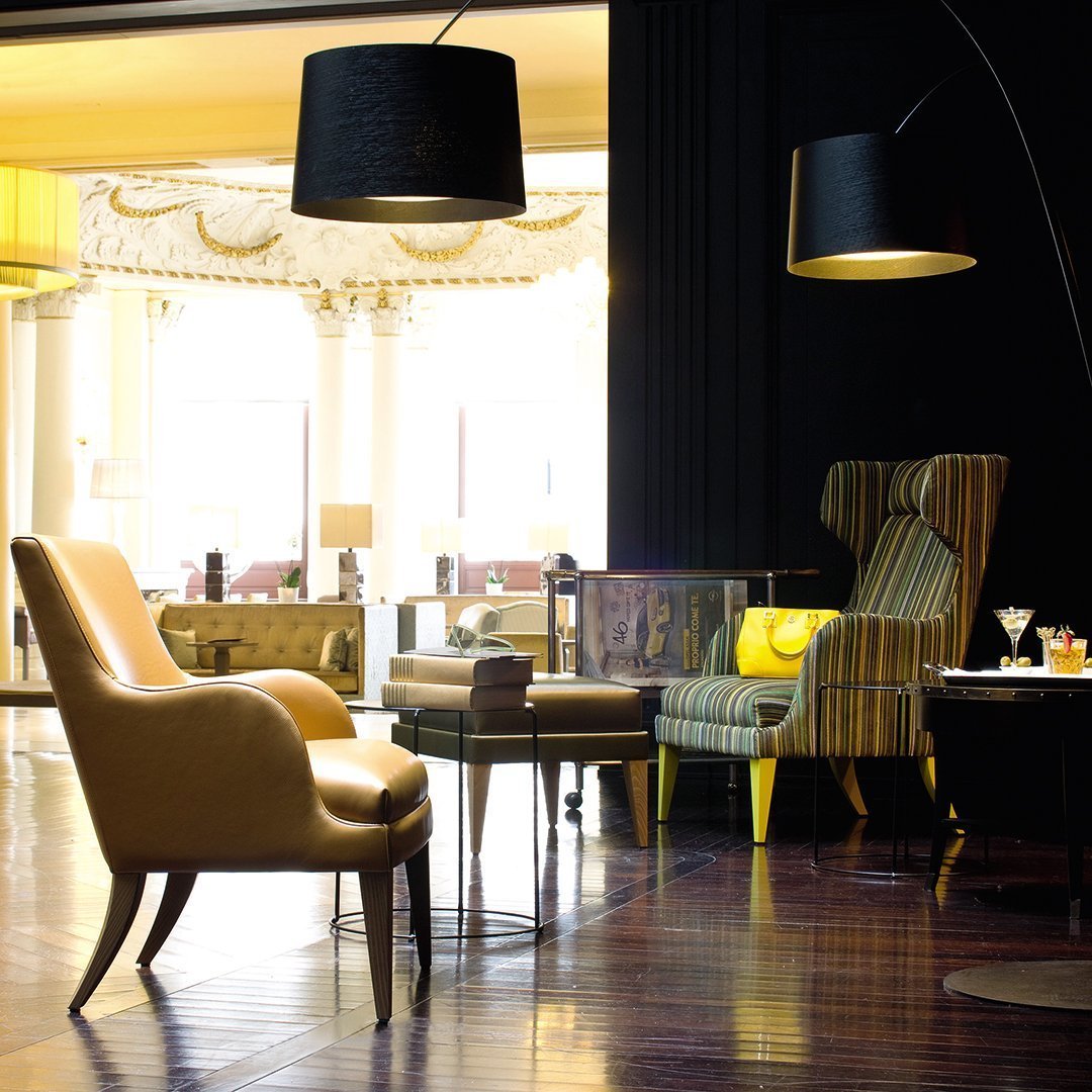 Elegant yellow leather and striped fabric chairs in a sophisticated interior with dark and warm light tones.