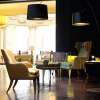 Elegant yellow leather and striped fabric chairs in a sophisticated interior with dark and warm light tones.