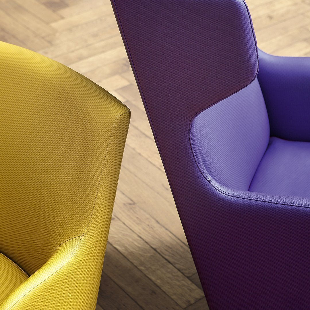 Yellow and purple modern chairs with sleek, smooth finishes against a warm wooden floor.
