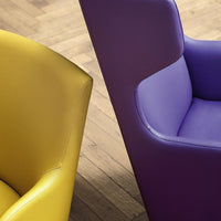 Yellow and purple modern chairs with sleek, smooth finishes against a warm wooden floor.