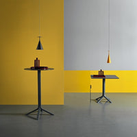 Stylish yellow and gray decor with modern tables and pendant lights, featuring bold geometric patterns.