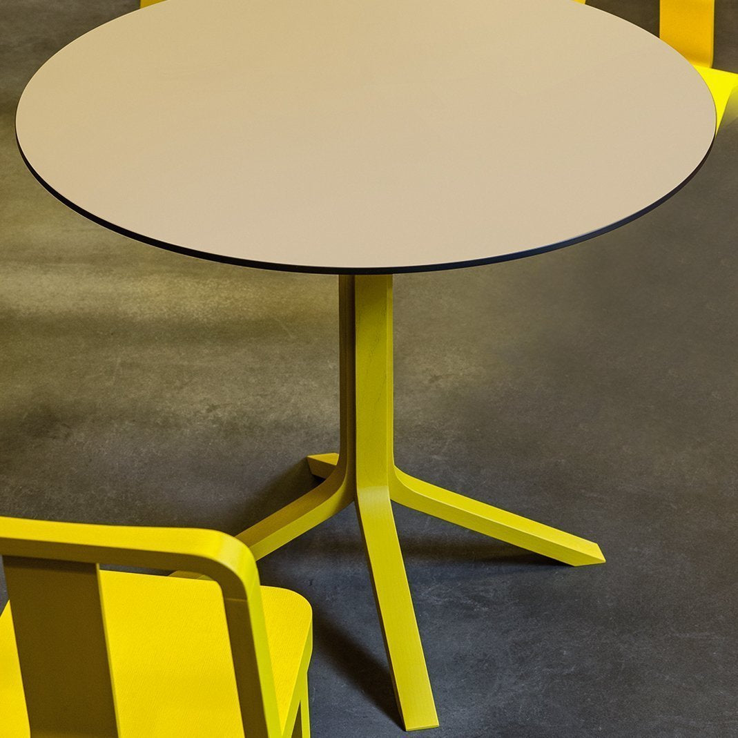 Round table with a light gray top and vibrant yellow legs, complementing bright yellow chairs.