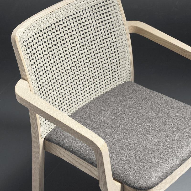 Light wood chair with a woven backrest and a gray upholstered seat, featuring a minimalist design and neutral colors.