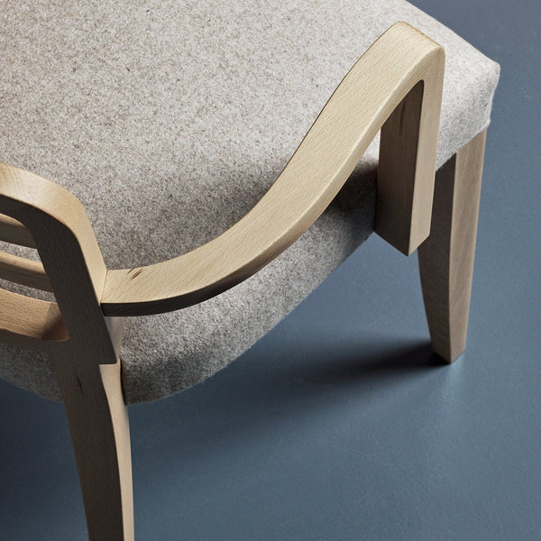 Light gray fabric chair with a smooth wooden frame and minimalist design, featuring elegant curves and subtle textures.