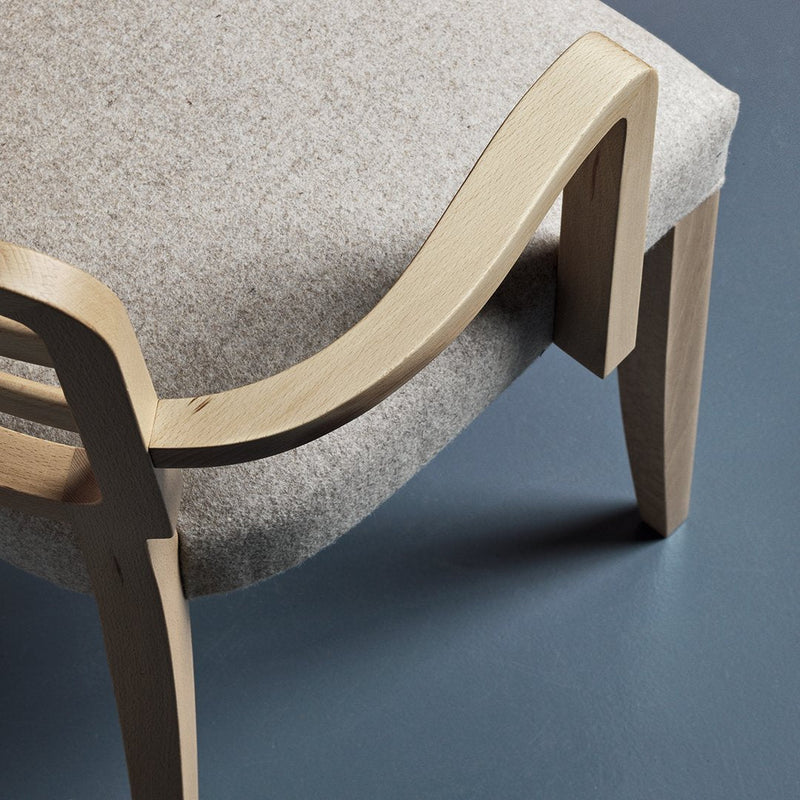 Light gray fabric chair with a smooth wooden frame and minimalist design, featuring elegant curves and subtle textures.