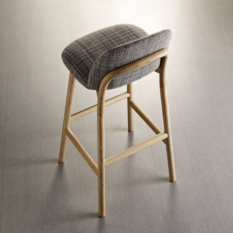 Gray plaid upholstered bar stool with light wood frame against a neutral floor. Modern design, stylish pattern.