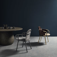 Modern chairs in gray and brown wicker with a minimalist round table against a dark blue wall. Stylish design elements.