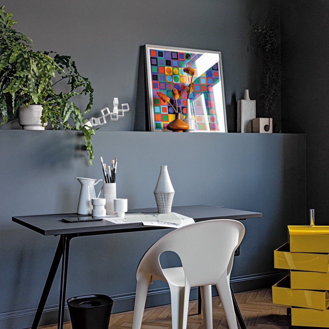 Modern workspace featuring a gray wall, colorful geometric art, and accents of yellow, white, and green.