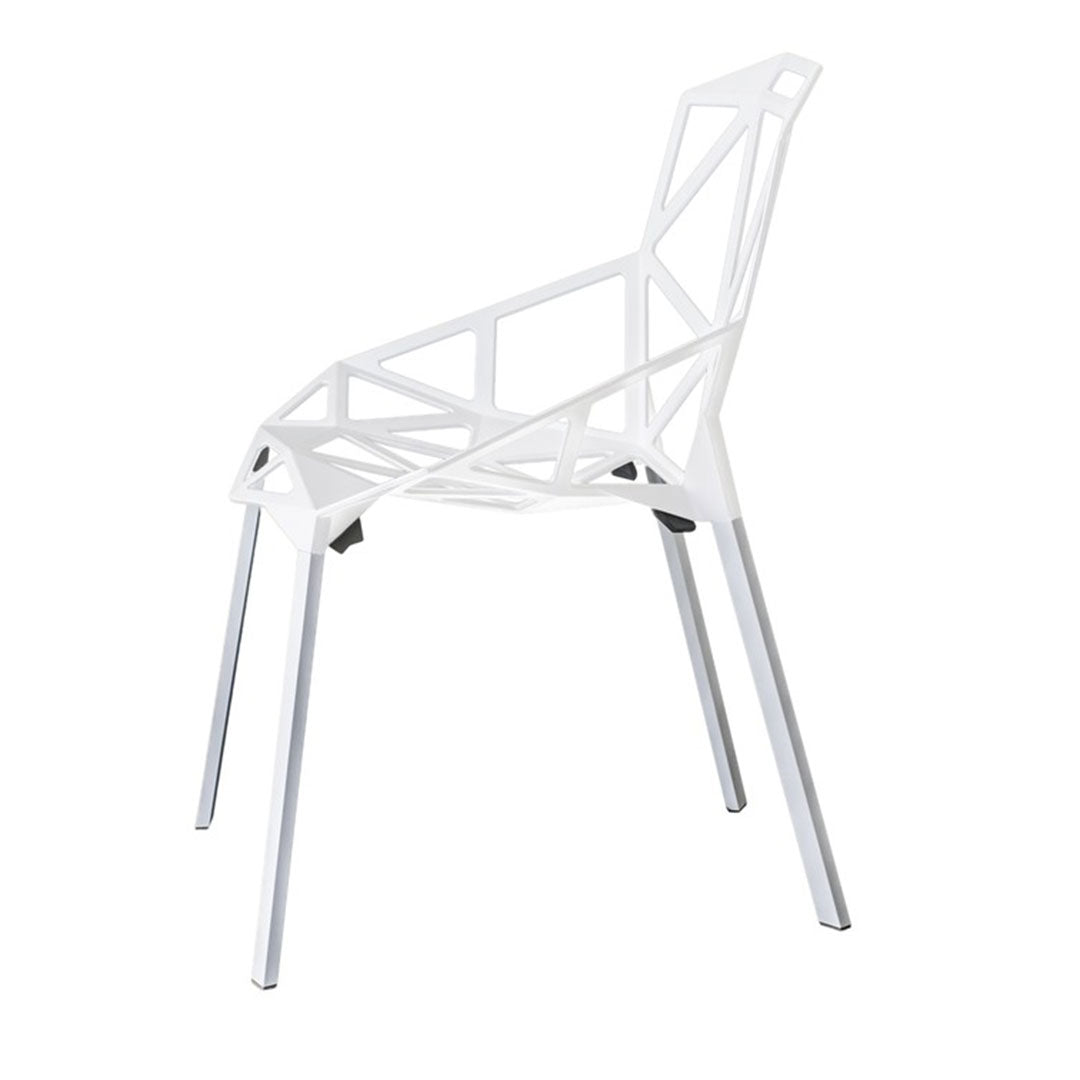 White geometric chair with intricate cutouts and sleek silver legs. Ideal modern design for any space.