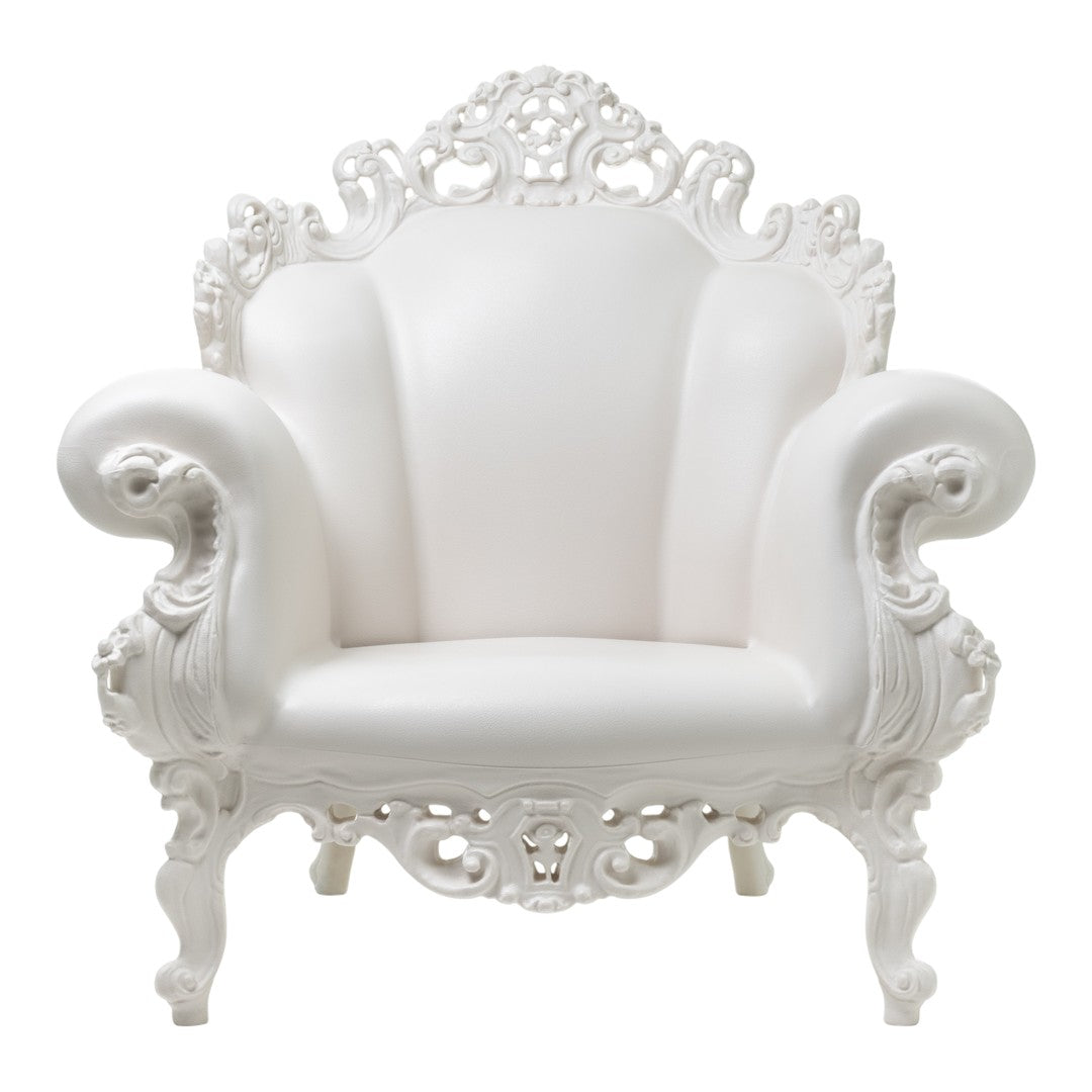 Elegant white armchair with ornate carved details and smooth upholstery, perfect for chic decor.