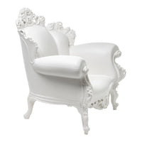 White ornate armchair with intricate detailing and a glossy finish, ideal for elegant decor.