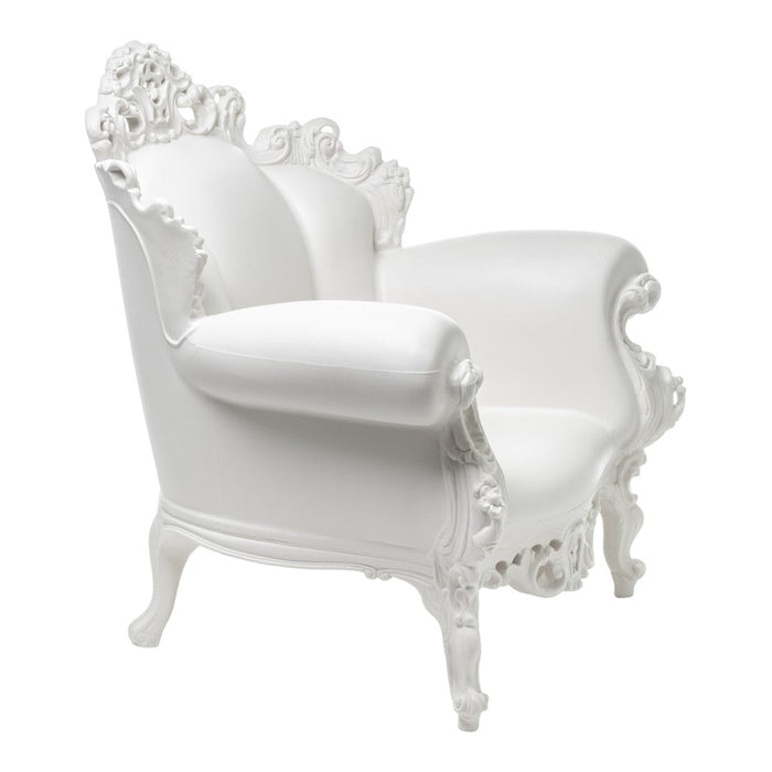 White ornate armchair with intricate detailing and a glossy finish, ideal for elegant decor.