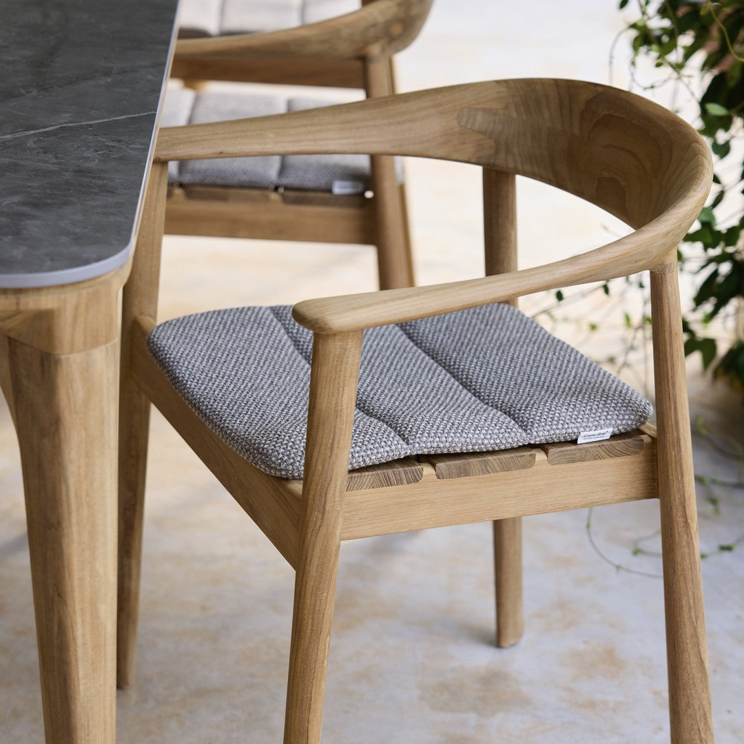 Natural wood chair with gray patterned cushion, perfect for indoor or outdoor settings. Elegant and stylish design.