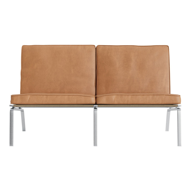 Tan leather loveseat with smooth texture and sleek chrome legs, minimalist design for modern interiors.
