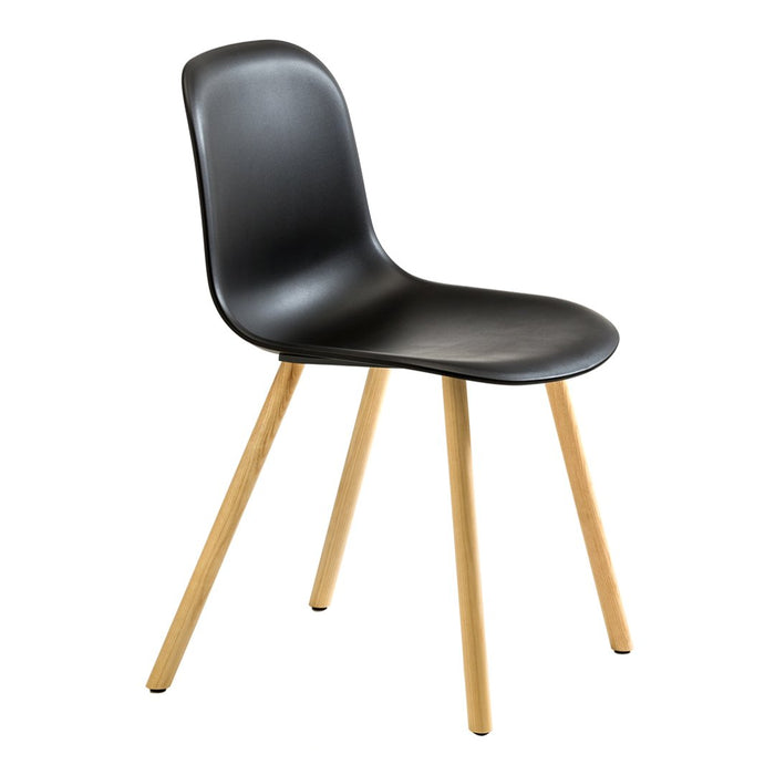 Black molded chair with natural wooden legs, featuring a sleek, minimalist design. Perfect for modern decor.