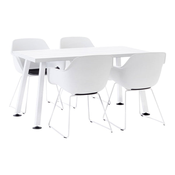 White modern dining table with four matching white chairs featuring black seat cushions. Clean, minimalist design.