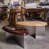 Two modern coffee tables featuring a glossy mahogany top and a natural wood finish, set on sleek stainless steel bases.