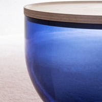 Blue glass bowl with a smooth finish and a light wooden top, featuring a modern and elegant design.
