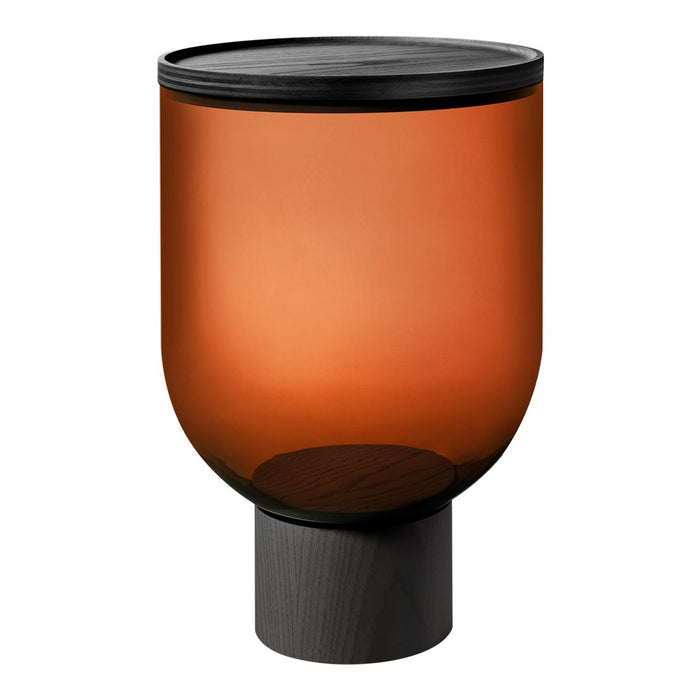Amber glass container with a matte black lid and a dark wooden base, featuring a smooth, rounded design.