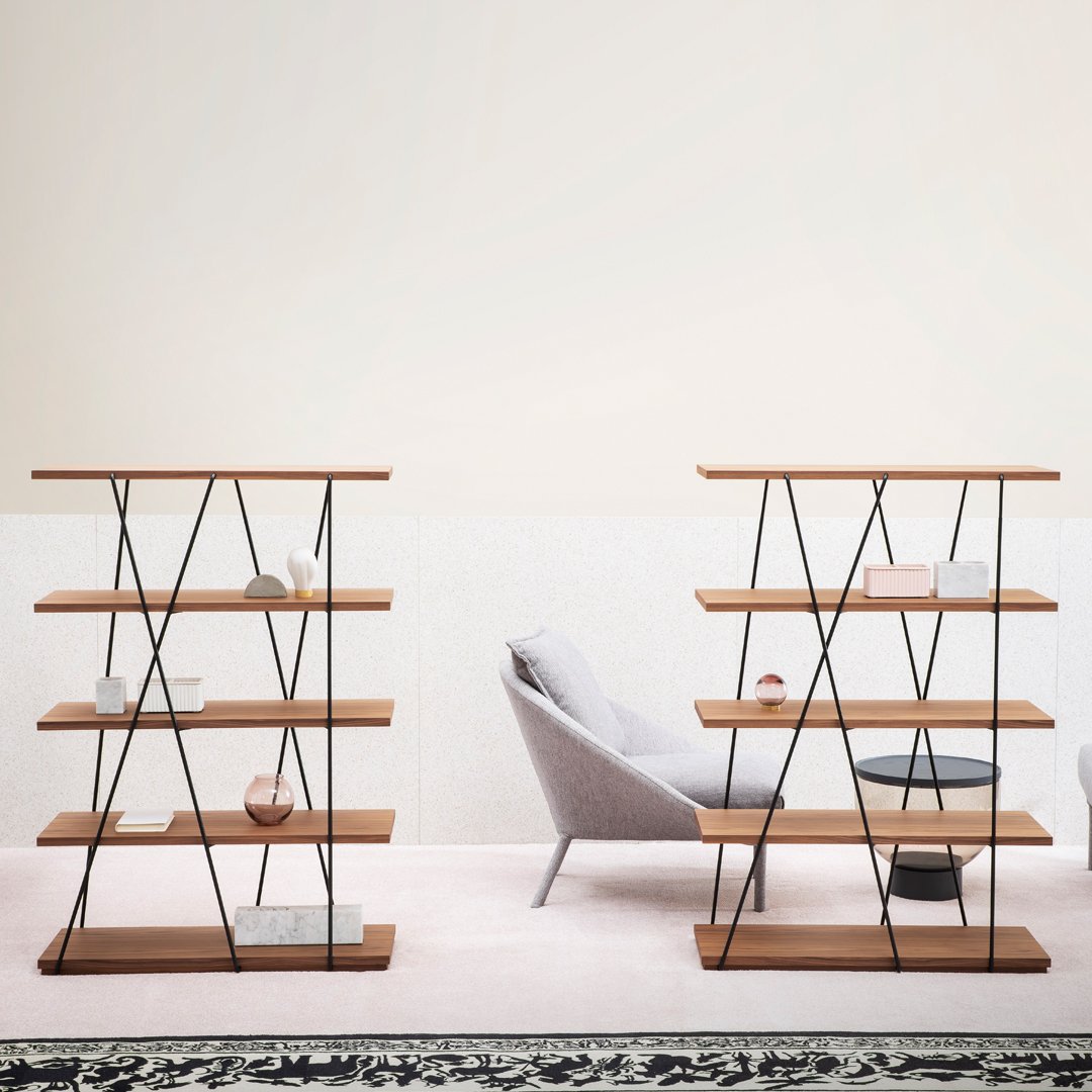 Wooden shelving units with black metal accents, featuring a warm brown finish and geometric patterns against a light backdrop.