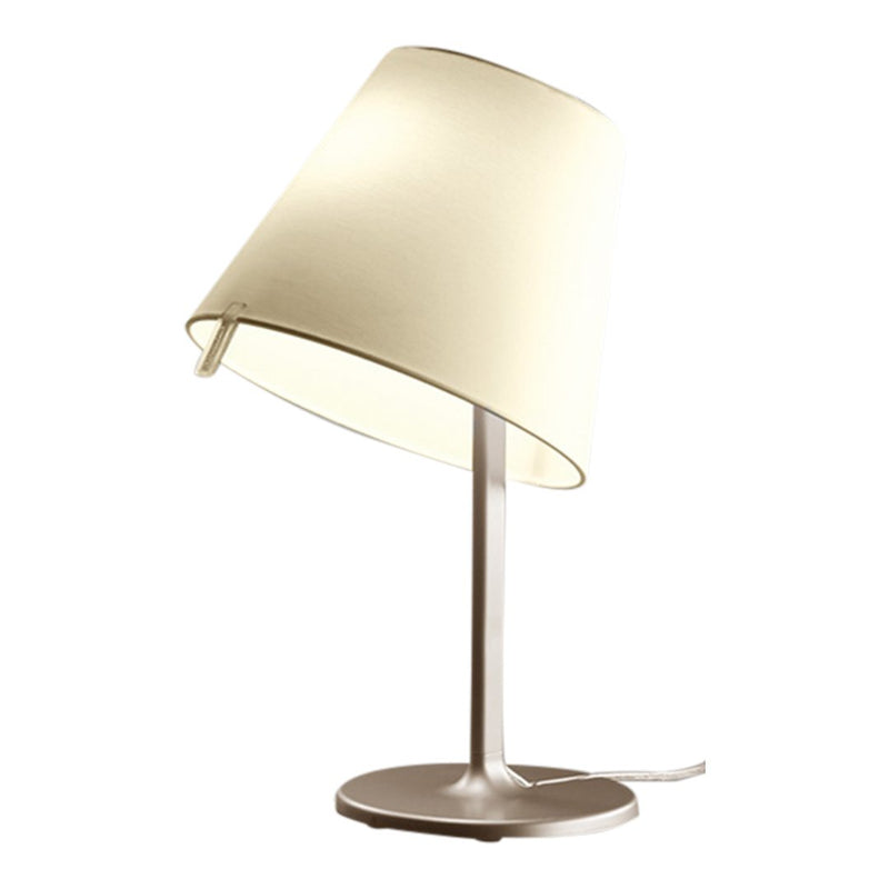 Cream-colored lampshade on a sleek metallic base, featuring a minimalist design and clean lines.
