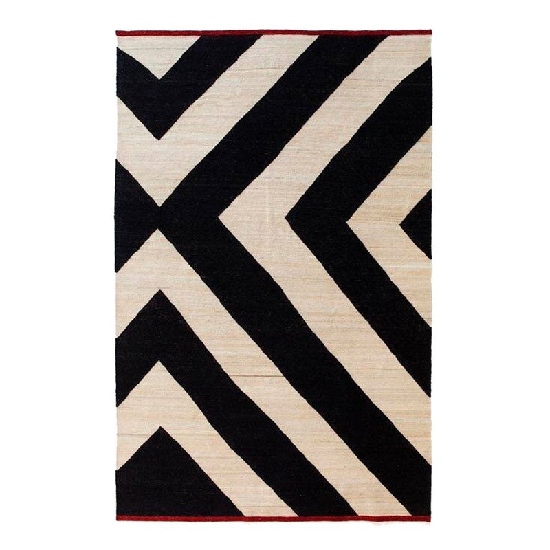 Black and ivory geometric zigzag pattern rug with a bold red border.