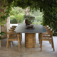 "Elegant black tabletop with natural wood tones and sleek, modern lines in a lush outdoor setting."