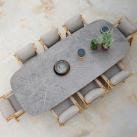 Gray marble dining table with natural wood accents and upholstered beige chairs, featuring clean lines and modern design.