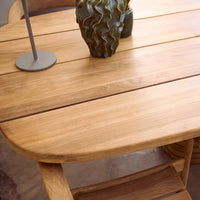 Light natural wood table with smooth grain and warm tones, complemented by a textured vase in earthy colors.