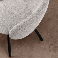 Grey textured chair with curved design and black legs, set against a neutral background. Ideal for modern decor.