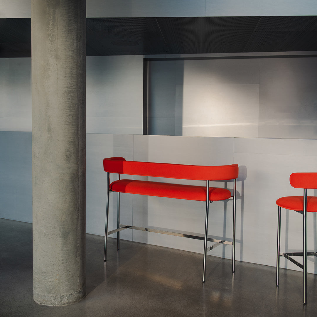 Stylish red bar stools with sleek silver frames against a modern gray and blue background.