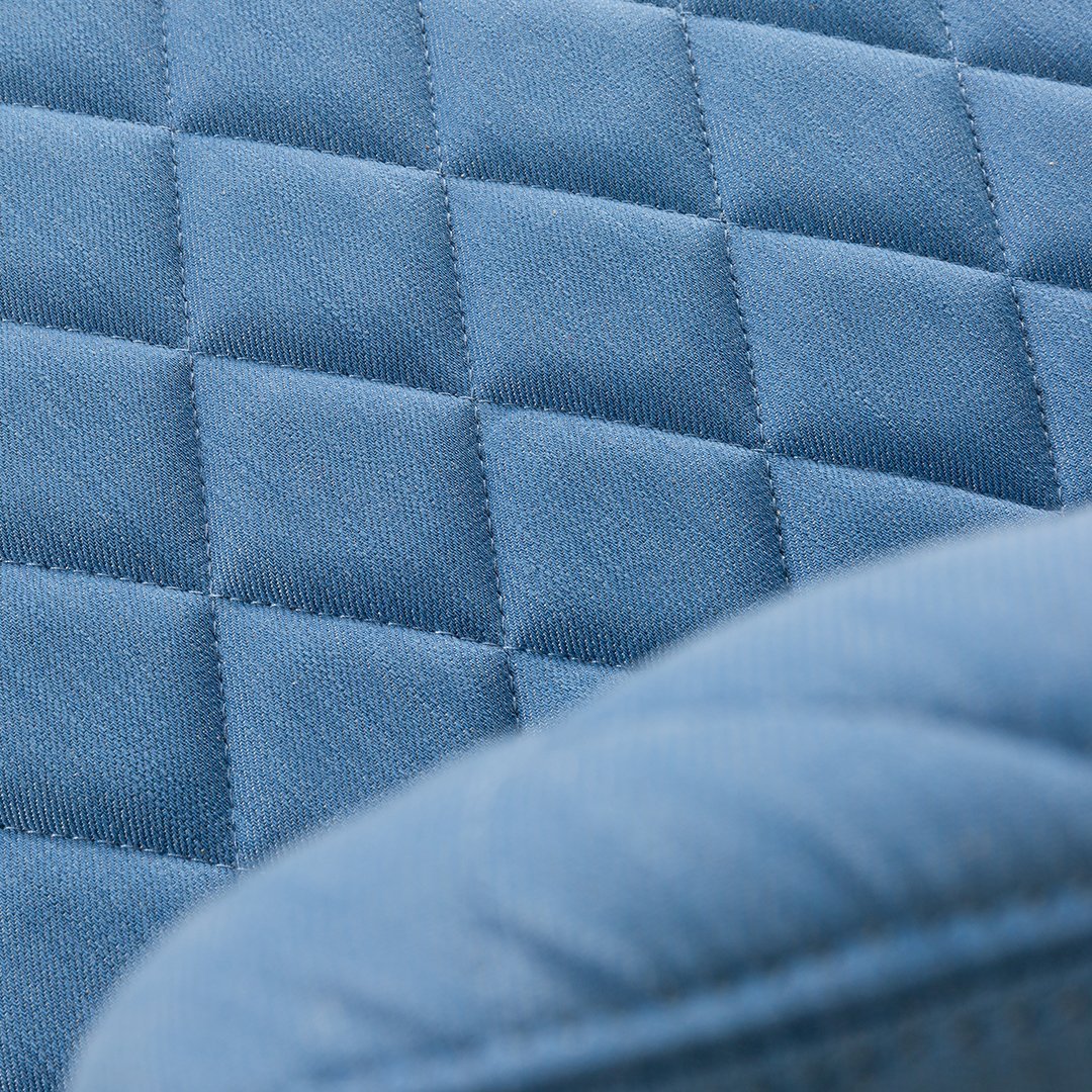 Textured light blue fabric with diamond quilted pattern, showcasing a soft and stylish design element.