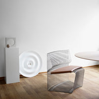 Modern wire chair with a sleek silver pattern and a warm brown seat, set against a minimalist white background.