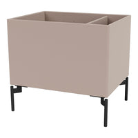 "Modern blush planter box with black metal legs; minimalist design for stylish indoor or outdoor decor."