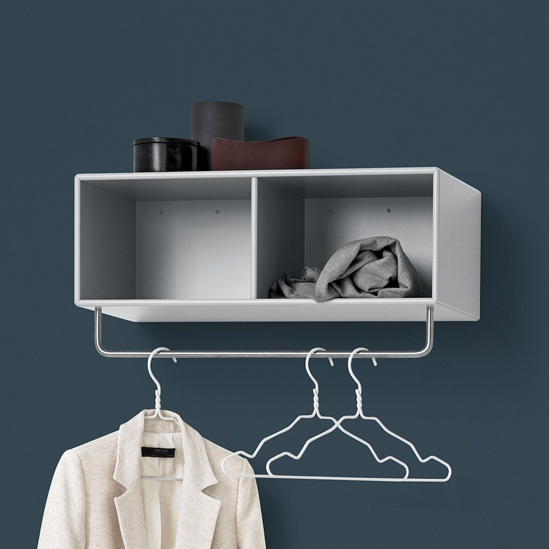 Gray wall-mounted storage with two compartments and a sleek silver hanging rod against a dark blue wall.