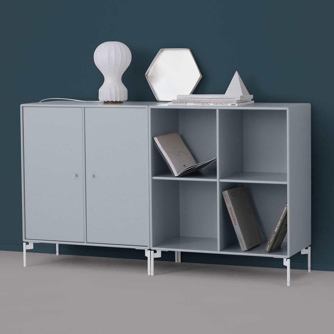 Light gray modern cabinet with clean lines, white accents, and a minimalist design against a dark blue wall.